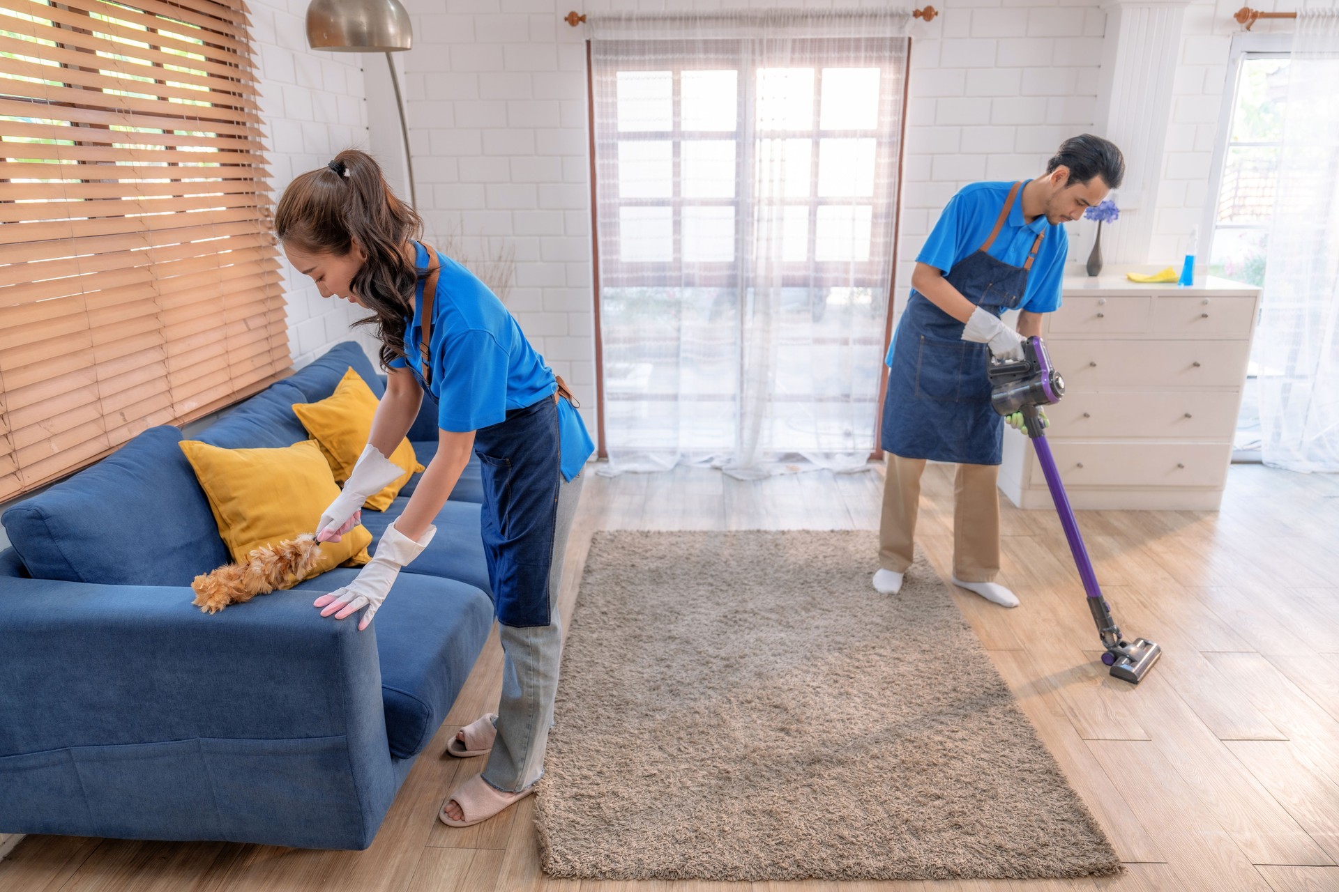 Male and female staff cleaning a home